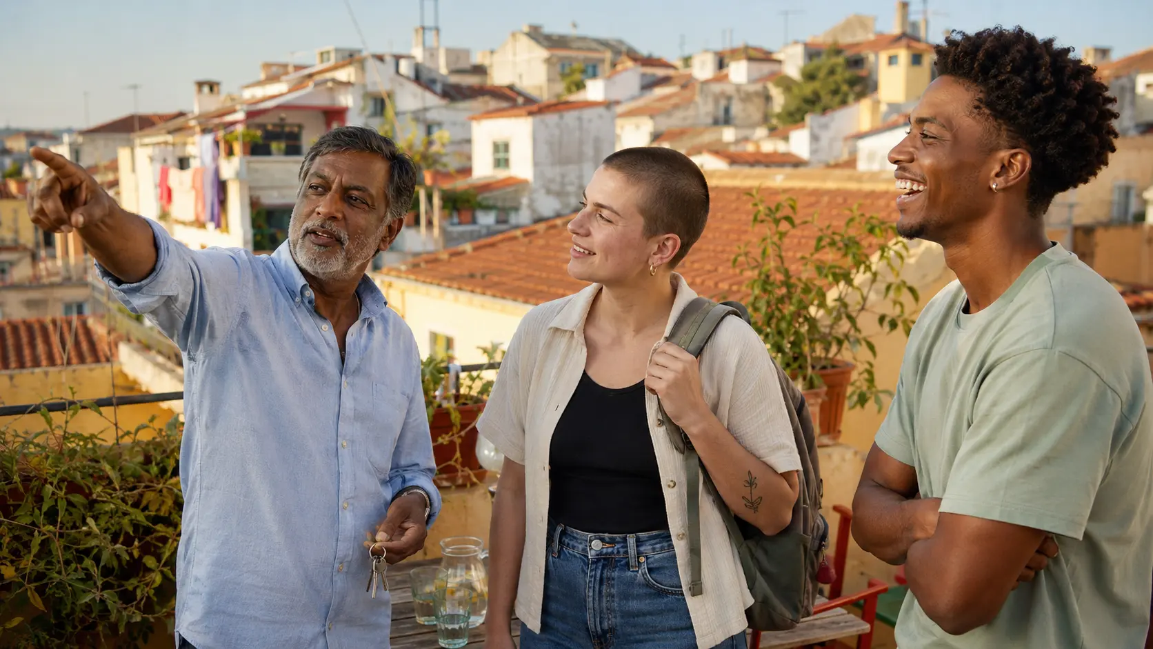 A host showing two travellers around the roof terrace of his flat